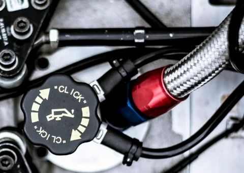 Braided fuel hose with a red AN fitting in an engine bay