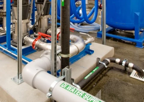 Grey PVC water supply line and pump skid piping
