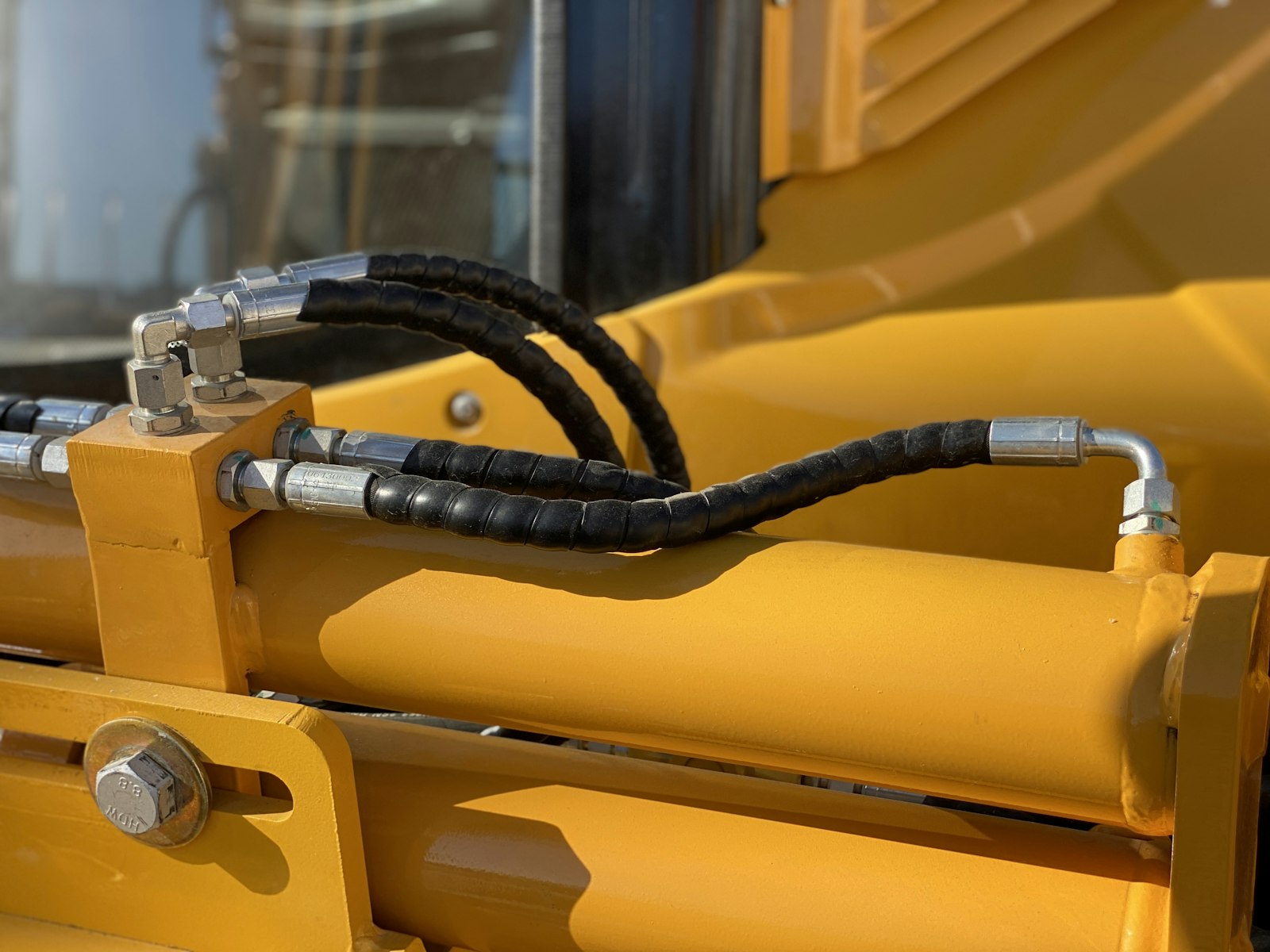 Hydraulic hoses and fittings on a new yellow machine