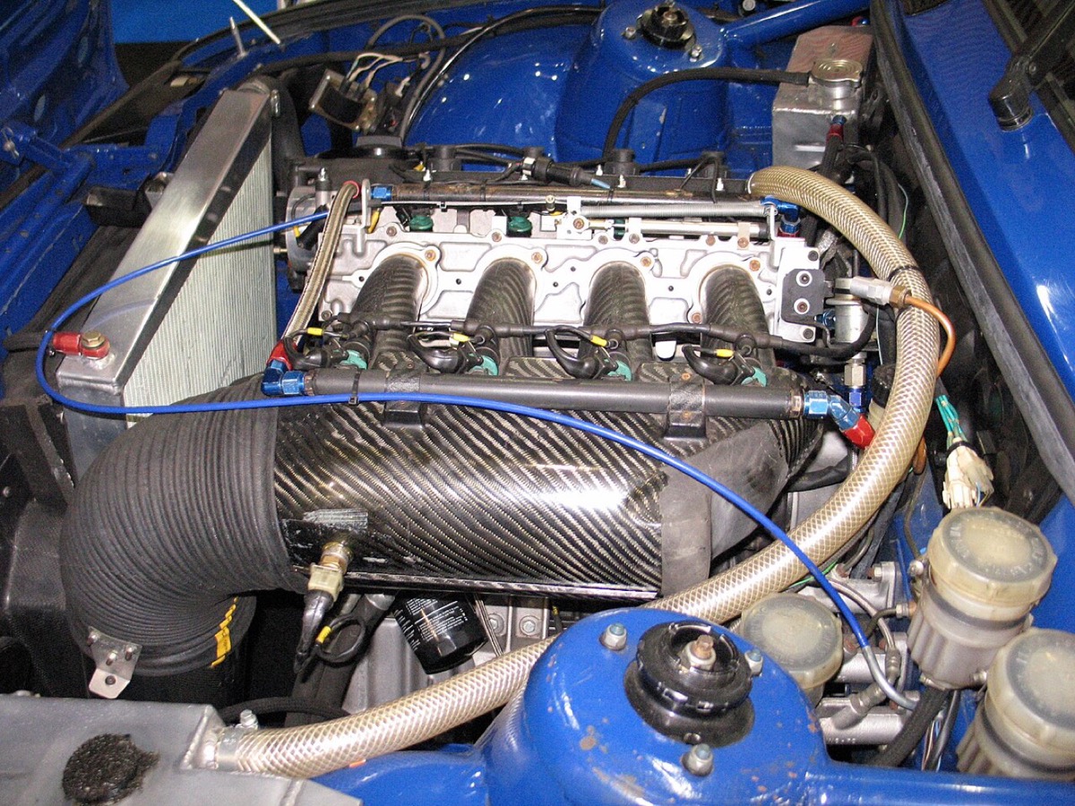 BMW E30 race car engine bay with carbon intake, fuel rail and anodized AN fittings